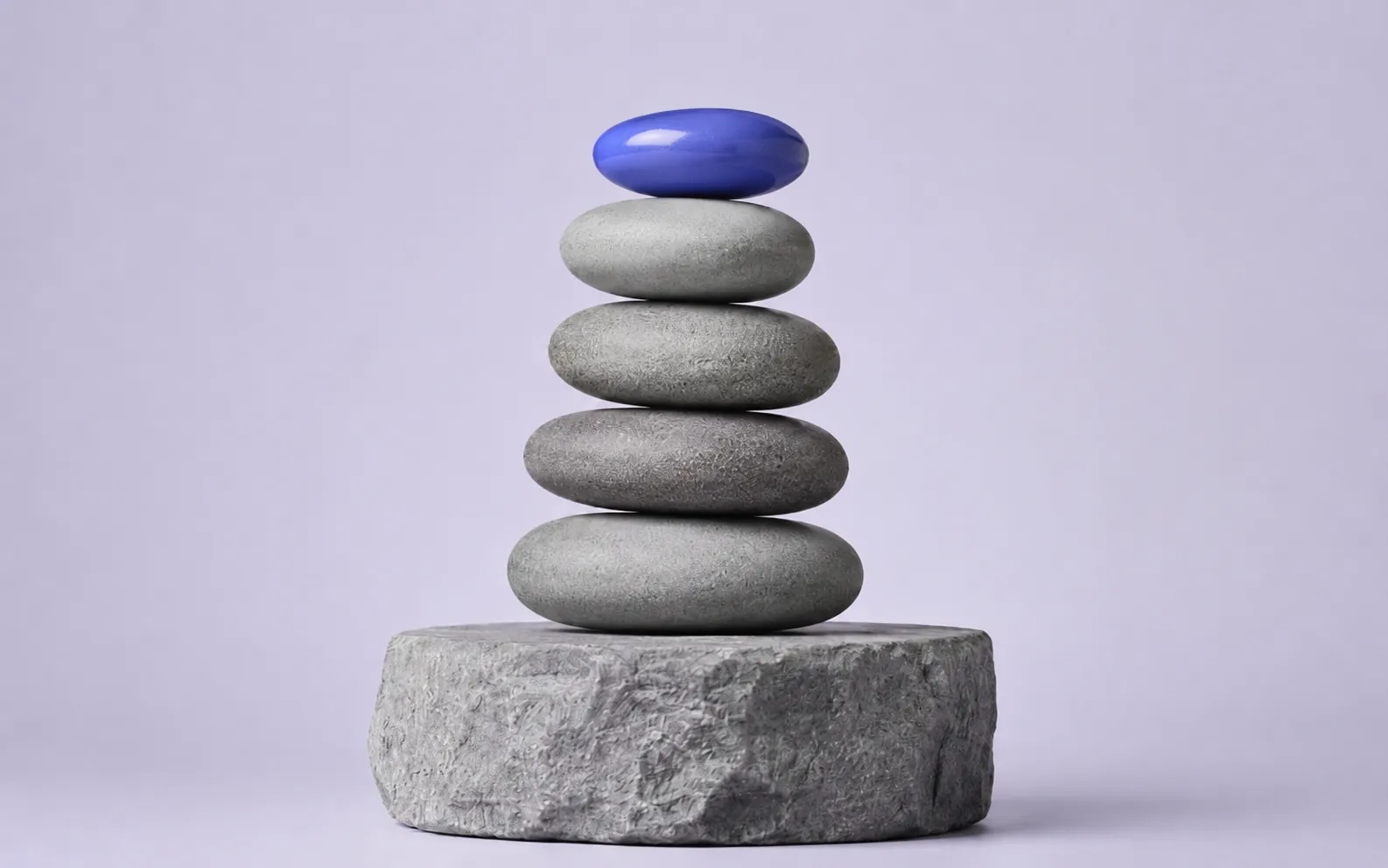 A balanced stack of stones with a blue capstone